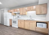 Thumbnail 14 of 22 - a kitchen with white appliances and wooden cabinets