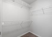 Thumbnail 17 of 53 - spacious closet with two shelves and two hanging racks in the corner of a room