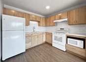Thumbnail 4 of 22 - an empty kitchen with white appliances and wooden cabinets