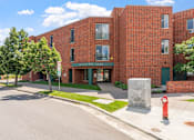 Thumbnail 2 of 25 - a red brick building with a sidewalk and a fire hydrant