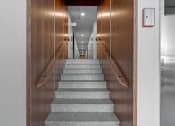 Thumbnail 6 of 45 - a staircase with grey carpeting leading up to a hallway with wooden doors