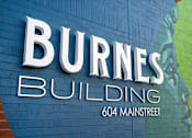 Thumbnail 1 of 26 - a sign for burns building on a blue brick wall