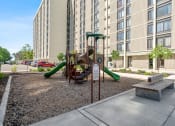 Thumbnail 11 of 51 - a playground in front of an apartment building with a swing set