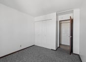 Thumbnail 36 of 51 - a bedroom with white walls and carpet and a door to a closet
