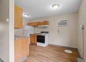 Thumbnail 9 of 57 - an empty kitchen with wood flooring and a stove and refrigerator