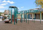 Thumbnail 22 of 25 - a playground with a slide and climbing equipment in front of a building