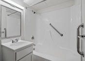 Thumbnail 43 of 51 - a bathroom with a sink and a shower and a mirror