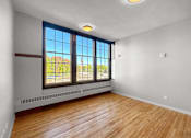 Thumbnail 15 of 24 - an empty living room with wood floors and large windows