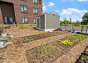 Thumbnail 52 of 53 - a garden in front of a brick building with a shed