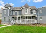 Thumbnail 16 of 27 - a blue house with a porch and a green lawn