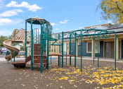 Thumbnail 24 of 25 - a playground with a slide and climbing equipment in front of a building