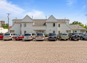 Thumbnail 48 of 67 - a parking lot full of cars in front of a white house