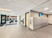 Thumbnail 7 of 17 - A hallway with a lobby area and a reception desk.