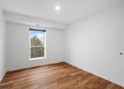 Thumbnail 22 of 36 - room with white walls and a window and wood floors