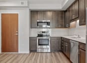 Thumbnail 14 of 45 - a kitchen with wooden cabinets and stainless steel appliances