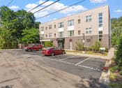 Thumbnail 52 of 52 - an apartment building with two cars parked in front of it