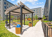 Thumbnail 38 of 53 - a park with benches and a pergola on a sidewalk