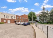 Thumbnail 29 of 31 - a parking lot with cars in front of a brick building