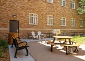Thumbnail 25 of 45 - a patio outside of a brick building with tables and chairs