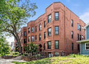 Thumbnail 46 of 67 - a red brick building with a tree in front of it