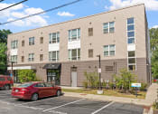 Thumbnail 51 of 52 - a large apartment building with cars parked in front of it