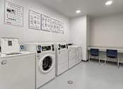 Thumbnail 19 of 22 - A laundromat with washers and dryers and instructions on the wall.