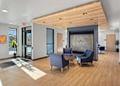 Thumbnail 22 of 22 - A modern office lobby with wooden floors and furniture.