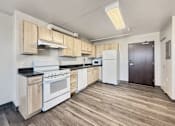 Thumbnail 8 of 17 - A kitchen with white appliances and wooden cabinets.