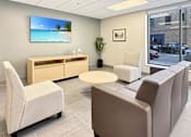 Thumbnail 3 of 17 - A waiting room with a flat screen TV mounted on the wall.