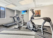 Thumbnail 13 of 17 - A gym with treadmills and exercise bikes.