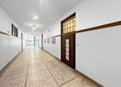 Thumbnail 11 of 24 - a long hallway with white walls and a door in the middle