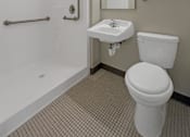 Thumbnail 11 of 17 - A white toilet sits next to a sink in a bathroom.
