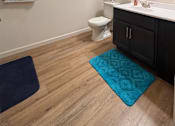 Thumbnail 34 of 34 - A bathroom with a toilet, sink, and mirror.