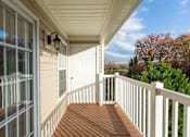 Thumbnail 9 of 78 - A porch with a white railing and a lamp on the wall.