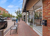 Thumbnail 39 of 47 - A brick sidewalk leads to a storefront with a black mailbox on the right.