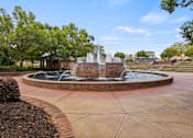 Thumbnail 37 of 47 - A fountain in the middle of a park surrounded by trees.
