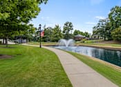 Thumbnail 35 of 47 - A park with a fountain and a flag.