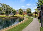 Thumbnail 34 of 47 - A serene park with a pond, gazebo, and walking path.