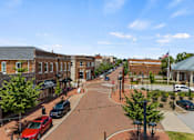 Thumbnail 33 of 47 - A street view of a town with cars parked on the side of the road.