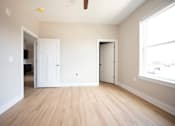 Thumbnail 12 of 47 - A room with a wooden floor and white walls.