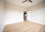 Thumbnail 8 of 47 - A room with a ceiling fan and wooden flooring.
