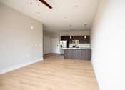 Thumbnail 16 of 47 - A kitchen with a wooden floor and a ceiling fan.