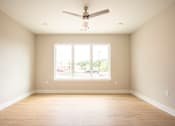 Thumbnail 22 of 47 - A room with a ceiling fan and a large window.