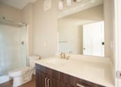 Thumbnail 10 of 47 - A bathroom with a toilet, sink, and mirror.