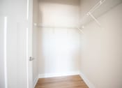Thumbnail 15 of 47 - A white door is on the left of a room with a white wall and a white shelf.