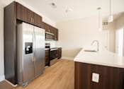 Thumbnail 6 of 47 - A modern kitchen with a stainless steel refrigerator and wooden cabinets.