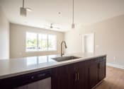 Thumbnail 4 of 47 - A kitchen with a black dishwasher and a white countertop.