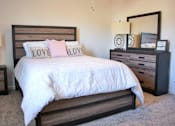 Thumbnail 35 of 37 - A bed with a white comforter and two pink pillows with the word LOVE on them.
