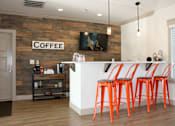 Thumbnail 17 of 37 - A coffee bar with a brick wall and orange stools.