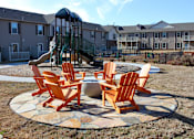 Thumbnail 8 of 37 - A fire pit surrounded by chairs in a grassy area.
